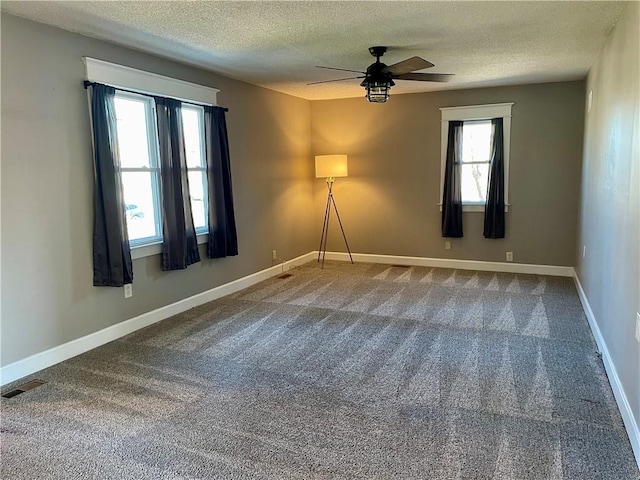 unfurnished room with visible vents, a ceiling fan, a textured ceiling, carpet flooring, and baseboards