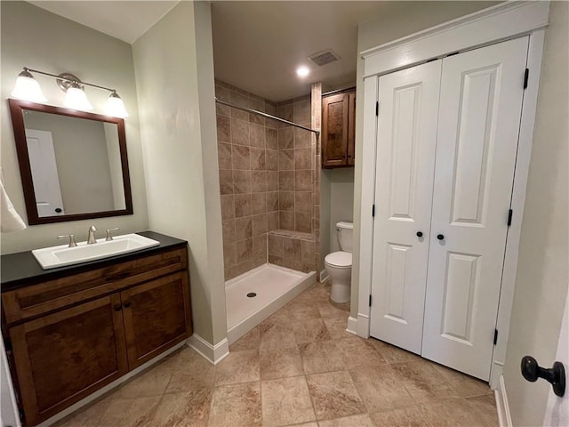 full bathroom featuring visible vents, toilet, a shower stall, baseboards, and vanity