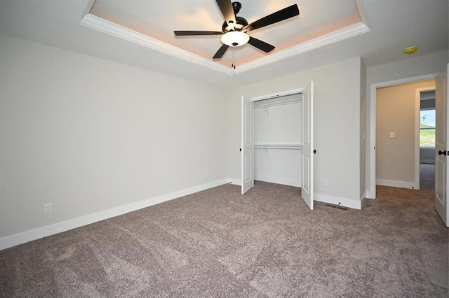 unfurnished bedroom featuring crown molding, a raised ceiling, and carpet