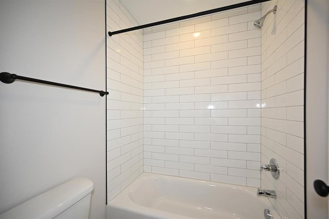 bathroom with tiled shower / bath combo and toilet