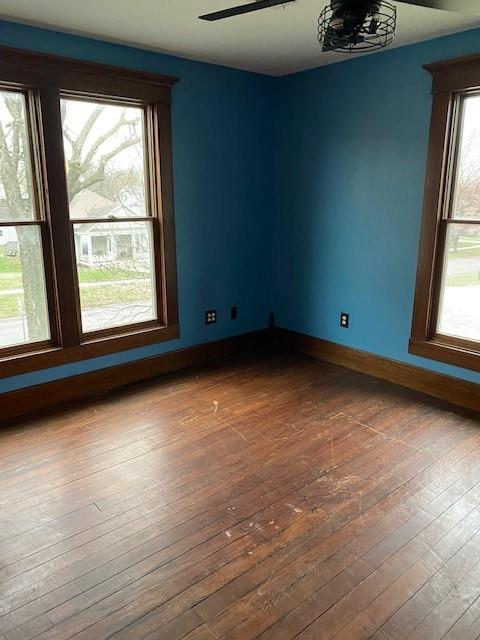 empty room with hardwood / wood-style flooring, plenty of natural light, and ceiling fan