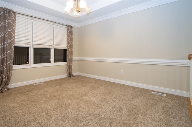 carpeted empty room featuring a notable chandelier and ornamental molding