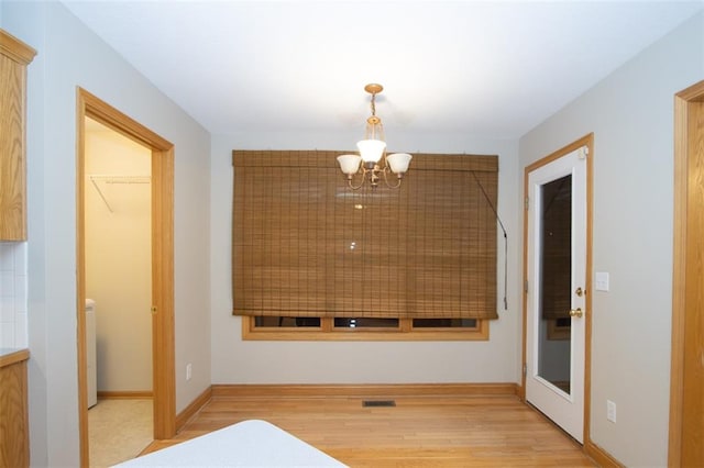 hall featuring a chandelier and light wood-type flooring