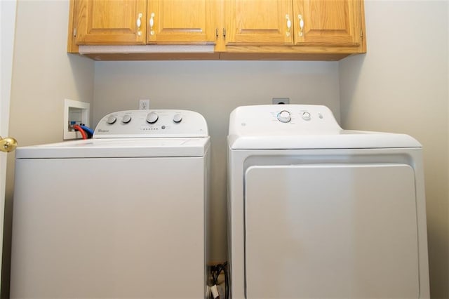 washroom with cabinets and washer and dryer