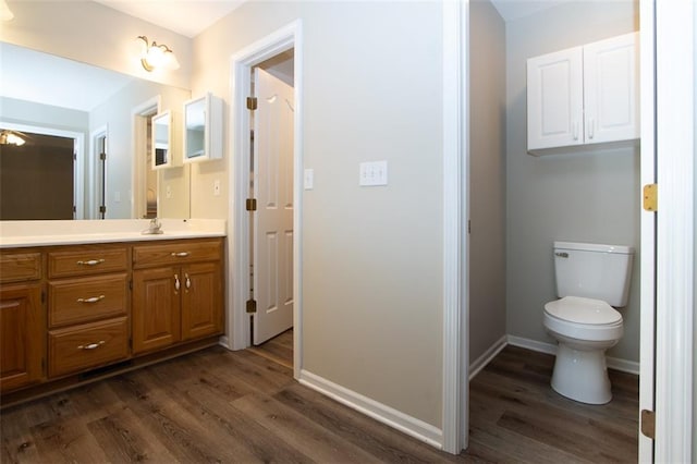 bathroom featuring vanity, toilet, and wood-type flooring