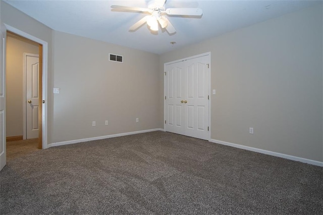 unfurnished bedroom with dark colored carpet and ceiling fan