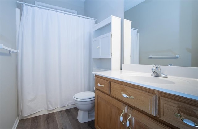 bathroom with toilet, vanity, and hardwood / wood-style flooring