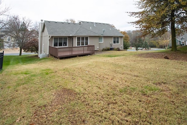 back of property featuring a lawn and a deck