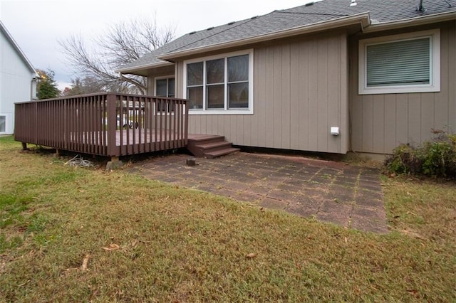 rear view of house featuring a lawn and a deck