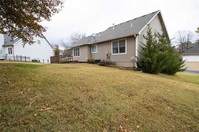 back of property with a wooden deck, a yard, and cooling unit