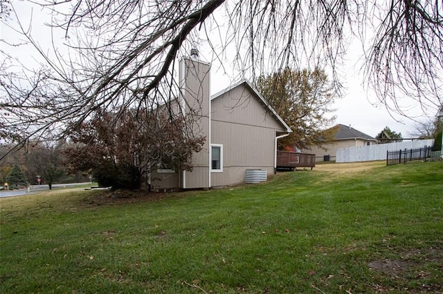 view of side of home featuring a lawn and a deck