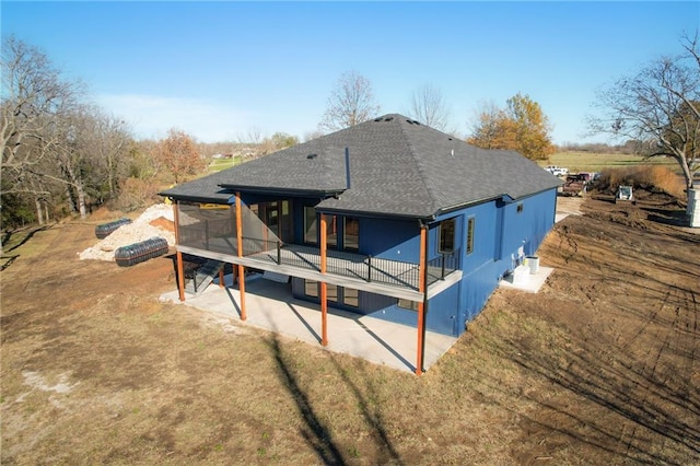 rear view of property featuring a patio and a sunroom