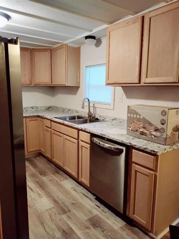 kitchen with light stone countertops, sink, light brown cabinets, stainless steel appliances, and light hardwood / wood-style flooring