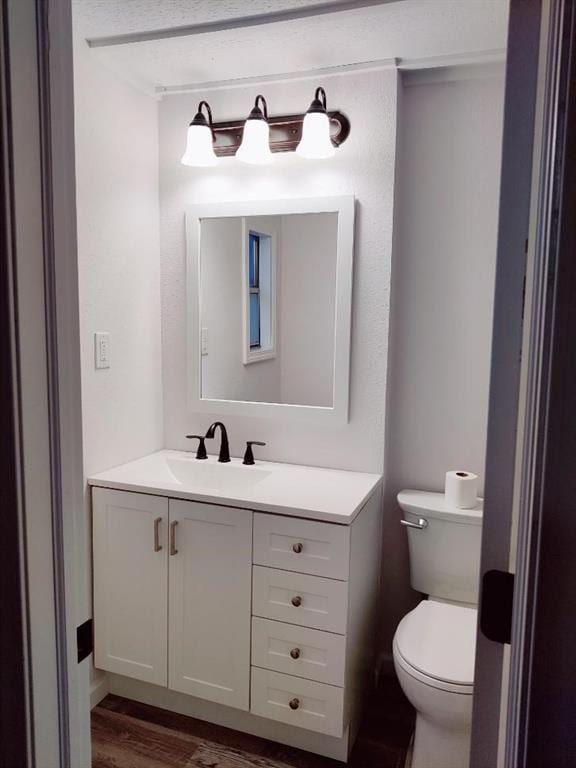 624 E 10th St, Fort Scott, KS 66701 - half bath featuring vanity, toilet, and wood finished floors