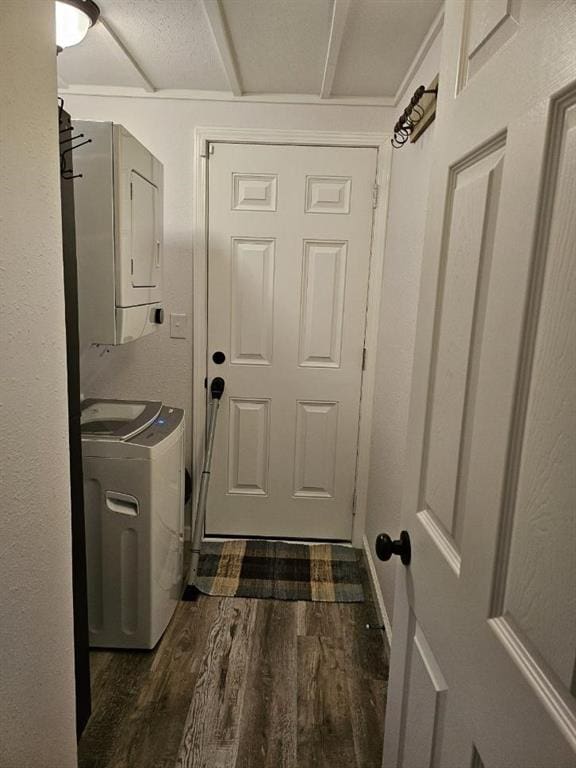 laundry area featuring dark wood-type flooring and stacked washer and clothes dryer