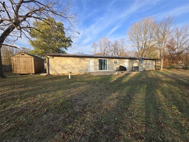 rear view of house with a lawn and a storage shed