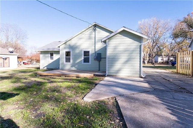 rear view of house featuring a lawn and a deck