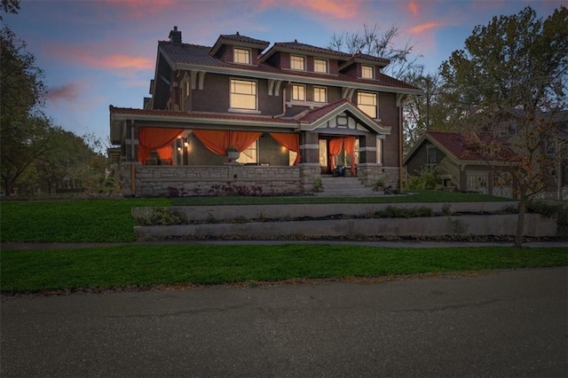 view of front of property featuring a lawn and a chimney