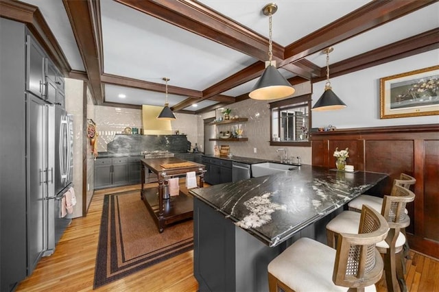 kitchen featuring a kitchen breakfast bar, beamed ceiling, a kitchen island, and pendant lighting