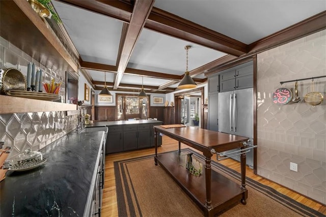 kitchen featuring hanging light fixtures, dark countertops, wood finished floors, and freestanding refrigerator