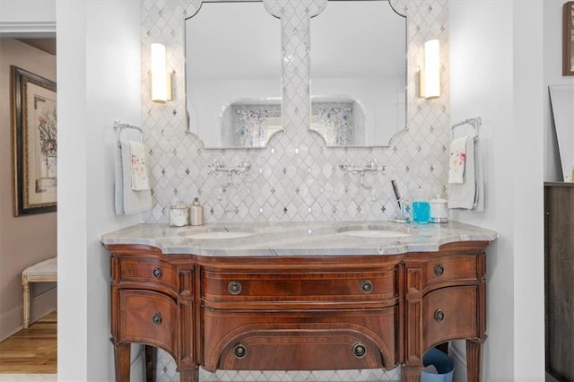 full bath with a sink, decorative backsplash, and double vanity