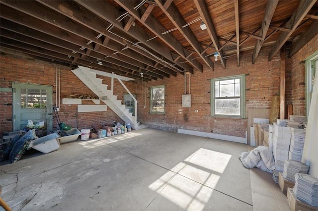 misc room featuring stairway and brick wall