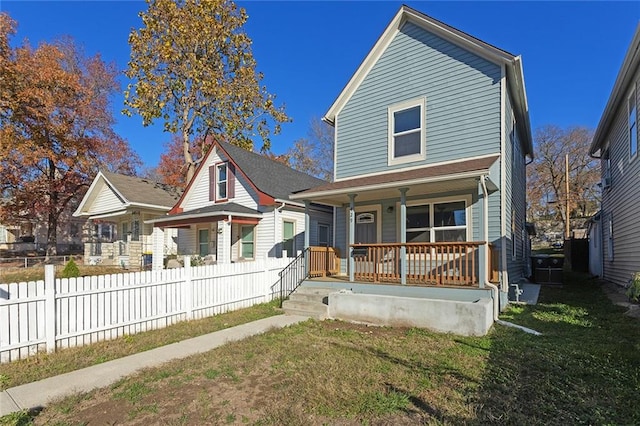 rear view of property featuring a lawn and a porch