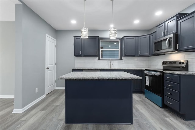 kitchen with a center island, sink, hanging light fixtures, light stone counters, and stainless steel appliances