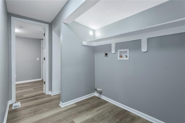 laundry room with electric dryer hookup, hookup for a washing machine, and wood-type flooring