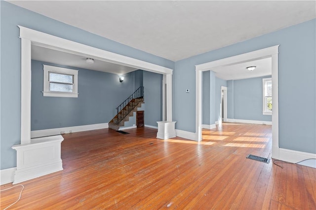 unfurnished living room featuring hardwood / wood-style flooring and a healthy amount of sunlight