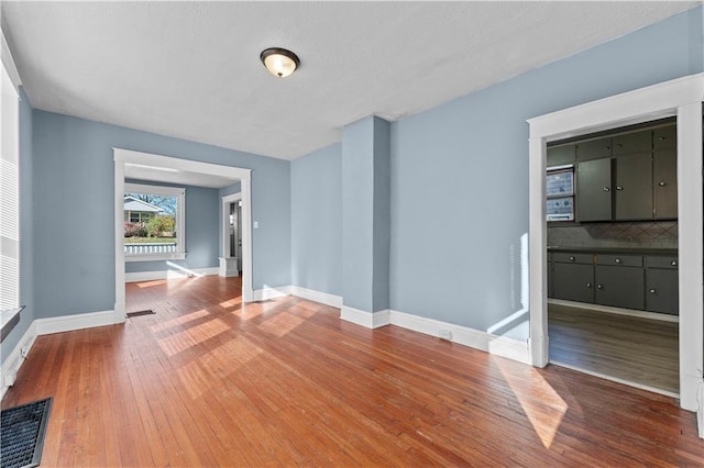 unfurnished room with hardwood / wood-style flooring