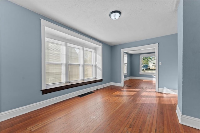 empty room featuring a textured ceiling and hardwood / wood-style flooring