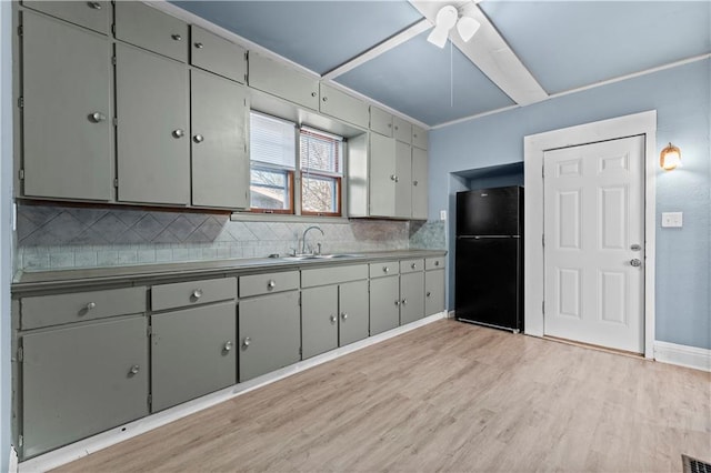 kitchen featuring gray cabinetry, black fridge, sink, and light hardwood / wood-style floors