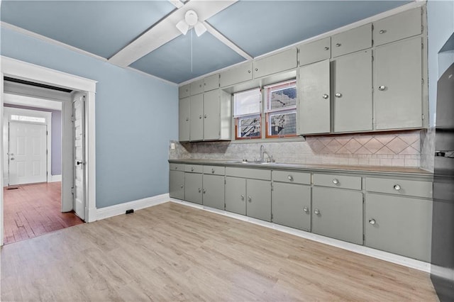 kitchen with gray cabinetry, ceiling fan, sink, tasteful backsplash, and light wood-type flooring