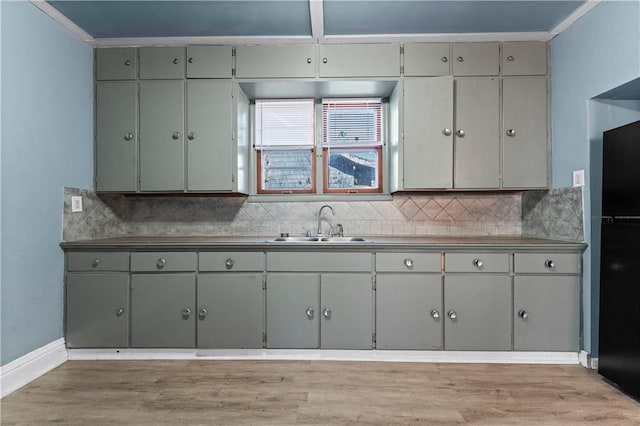 kitchen with backsplash, gray cabinets, crown molding, and sink