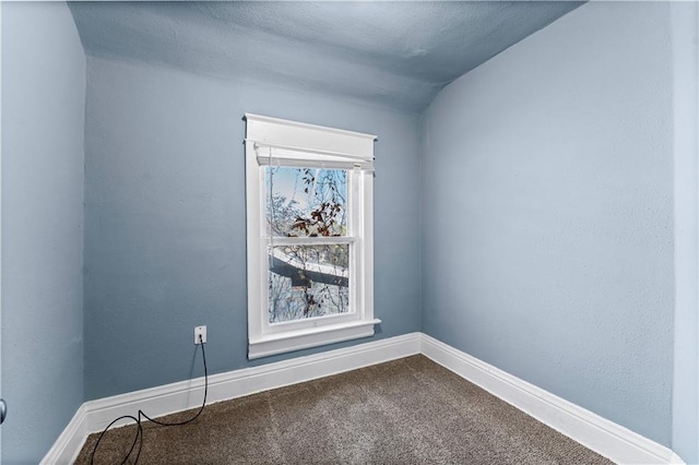 empty room with lofted ceiling and carpet floors