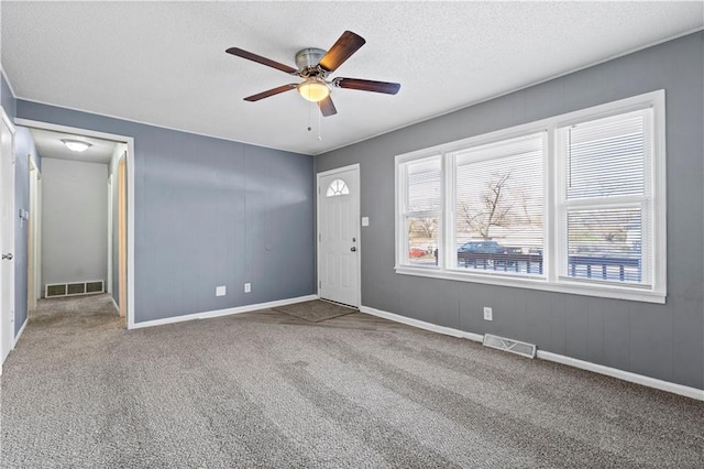 carpeted entrance foyer featuring a textured ceiling and ceiling fan