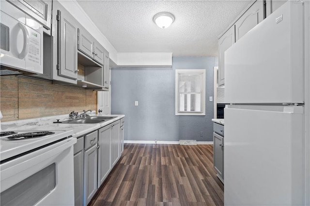 kitchen with gray cabinetry, decorative backsplash, sink, and white appliances