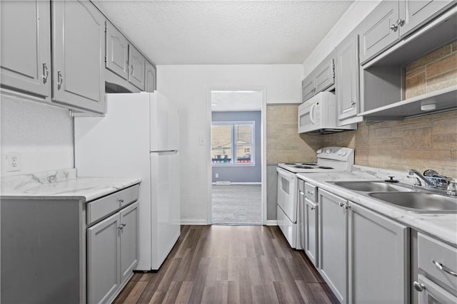 kitchen featuring a textured ceiling, white appliances, gray cabinetry, and sink