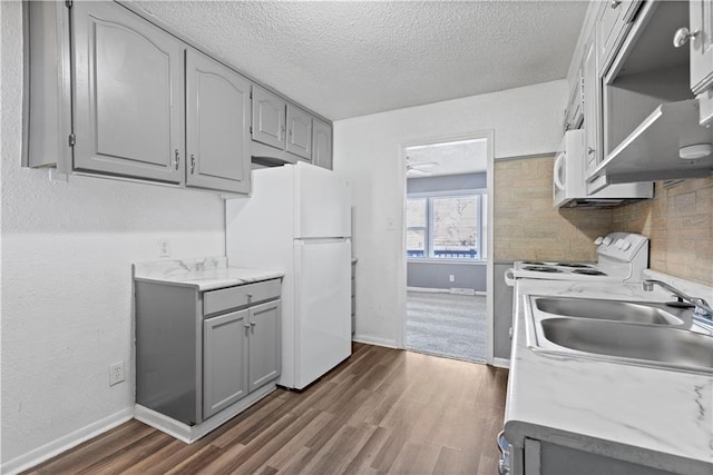 kitchen featuring gray cabinets, sink, dark hardwood / wood-style floors, and white appliances