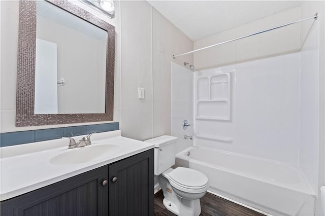 full bathroom featuring washtub / shower combination, tasteful backsplash, wood-type flooring, toilet, and vanity