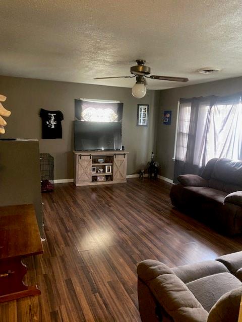 living room featuring a textured ceiling, dark hardwood / wood-style flooring, and ceiling fan