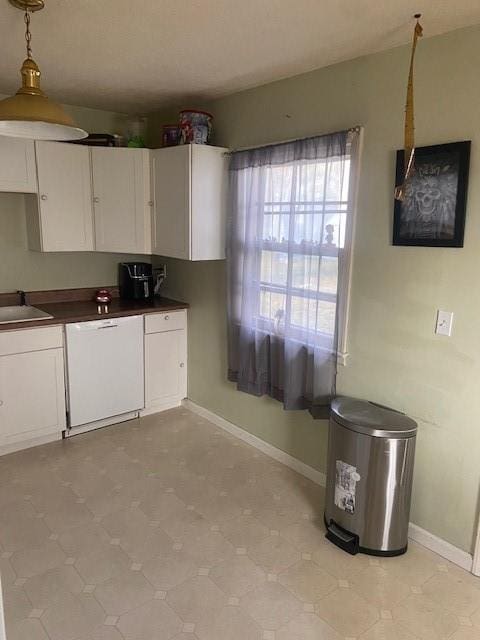 kitchen featuring white cabinetry, sink, white dishwasher, and decorative light fixtures