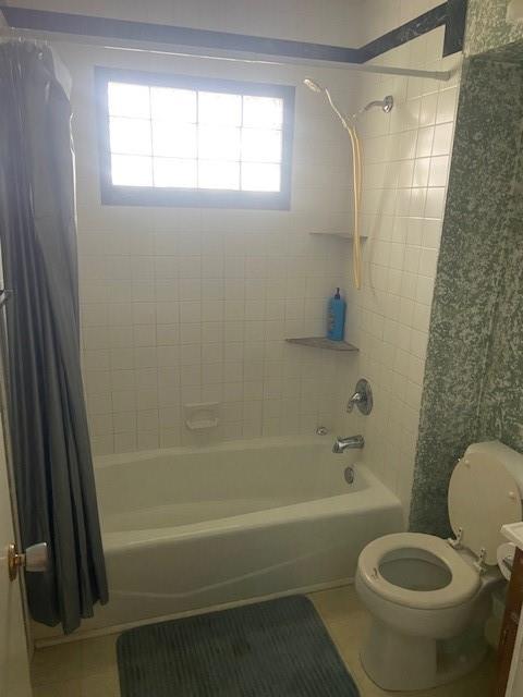 bathroom with tile patterned floors, a healthy amount of sunlight, toilet, and shower / bathtub combination with curtain