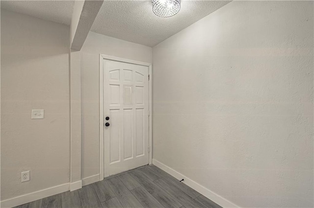 doorway to outside with dark hardwood / wood-style floors and a textured ceiling