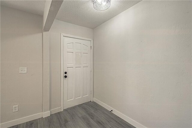 328 Virginia Rd, Excelsior Springs, MO 64024 - doorway to outside with baseboards, dark wood-type flooring, and a textured ceiling