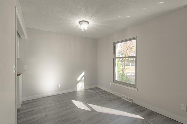 328 Virginia Rd, Excelsior Springs, MO 64024 - empty room with baseboards, wood finished floors, and a textured ceiling