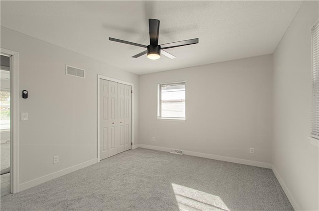 unfurnished bedroom with a closet, ceiling fan, and light colored carpet