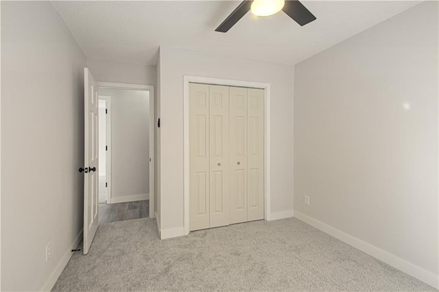 unfurnished bedroom featuring ceiling fan, light carpet, and a closet