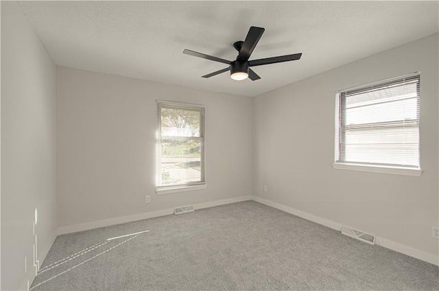 spare room with ceiling fan and light carpet